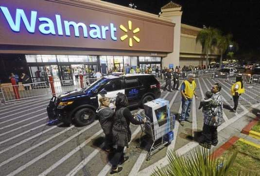 Rialto police vehicles sit outside the Rialto Walmart Thursday night after fights occurred at the store. Police said there were three fights shortly after 7 p.m. at the store at 1610 S. Riverside Ave., two of which were inside over merchandise and the third outside that caused injury to an officer. Will Lester – Staff Photographer 